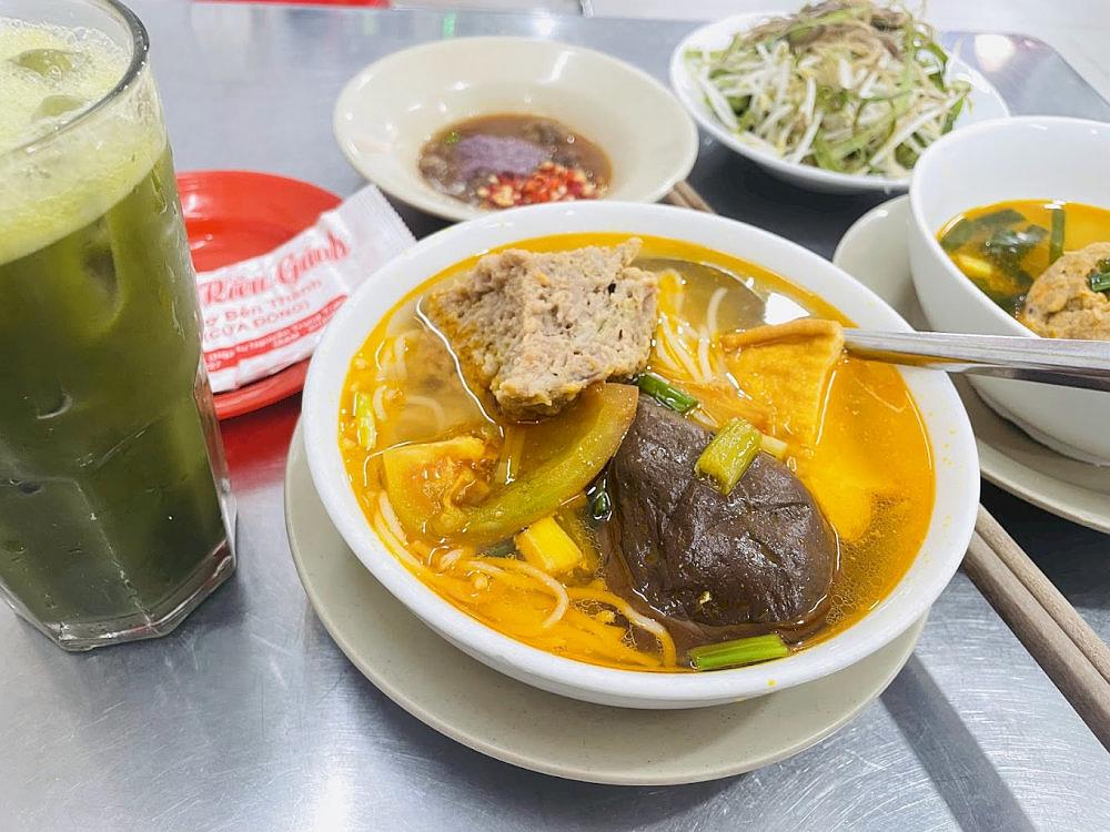 A steaming bowl of bun rieu, rich in the signature aroma of field crab and packed with irresistible color
